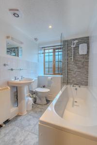 y baño con bañera, lavabo y aseo. en Yr Eifl Cottage, en Llanfairpwllgwyngyll