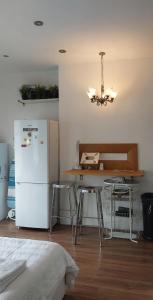 a kitchen with a white refrigerator and a table with stools at cally in London