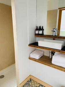 a bathroom with a sink and a mirror and towels at NIDS SAUVAGES - Villa unique en baie de Somme in Saint-Quentin-en-Tourmont