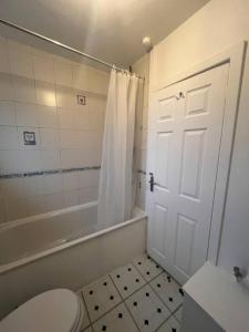 a bathroom with a toilet and a tub and a shower at Spacious House in Hertfordshire in Borehamwood