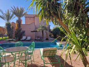 eine Terrasse mit Tischen und Stühlen neben einem Pool in der Unterkunft Manzal Lahbab, 2Villas 2Bungalows 2Piscines et Jardins in Marrakesch