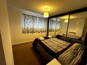 a hotel room with two beds and a mirror at Spacious House in Hertfordshire in Borehamwood