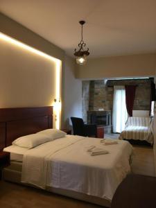 a bedroom with a large white bed and a chair at Tasia Mountain Hotel in Chania