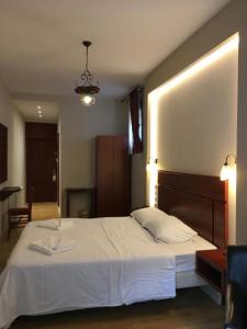 a bedroom with a large bed with white sheets at Tasia Mountain Hotel in Chania