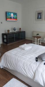 a white bed in a room with a tv on the wall at cally in London