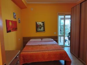 1 dormitorio con paredes de color naranja y 1 cama. en La Vecchia Taverna 