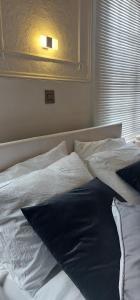 倫敦的住宿－cally，一张带白色床单和蓝色枕头的床