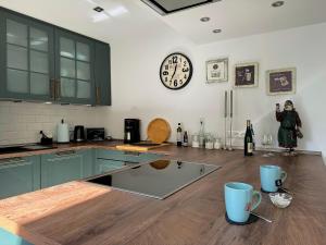a kitchen with a counter and a clock on the wall at Ferienhaus Merl in Zell an der Mosel