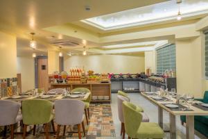 a restaurant with tables and chairs and a counter at Regenta Central Puri Odisha in Puri