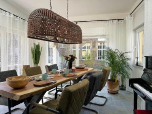 a dining room with a table and a large chandelier at Ferienhaus Merl in Zell an der Mosel