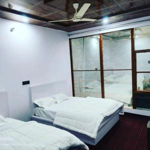 Duas camas num quarto com uma janela em Kedar Hill Resort em Kedārnāth