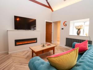 a living room with a couch and a fireplace at Mayfield Cottage in Malmesbury