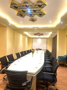 une grande salle de conférence avec une grande table blanche et des chaises dans l'établissement Green valley boutique, à Paro