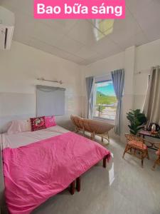 a bedroom with a pink bed and a table and a window at Homestay Tuyết Trinh in Nha Trang +208 photos