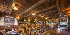 a restaurant with wooden tables and chairs in a room at 4Roses Apartments in Vysoke Tatry - Stary Smokovec