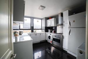 a kitchen with white appliances and a black floor at Park Lorne in London
