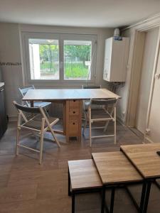 une chambre avec une table, des chaises et une fenêtre dans l'établissement appartement avec garage et terrasse, à Bourges