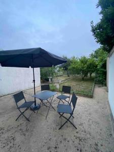 una mesa y sillas con una sombrilla en un patio en appartement avec garage et terrasse en Bourges