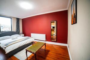 um quarto com paredes vermelhas, uma cama e uma mesa em Park Lorne em Londres