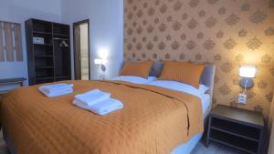 a bedroom with a large bed with towels on it at Premium City Centre Bedrooms in Prešov