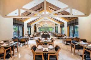 a restaurant with wooden tables and chairs and windows at Batıhan Vadi Hotel in Kuşadası