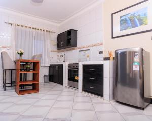 a kitchen with a stainless steel refrigerator and appliances at Greenwoods Apartments in Kampala