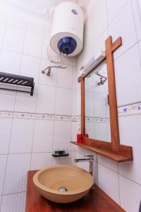 ein Badezimmer mit einem Waschbecken und einem Licht an der Wand in der Unterkunft Greenwoods Apartments in Kampala