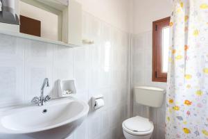 a white bathroom with a sink and a toilet at MON REPOS in Panormos Skopelos