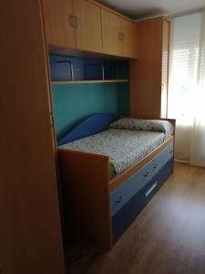 a small bed in a room with wooden cabinets at Apartamento El Prado in Almazán
