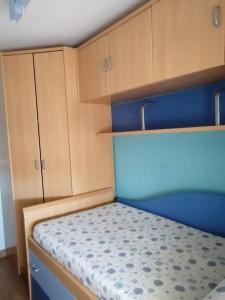 a small bedroom with wooden cabinets and a bed at Apartamento El Prado in Almazán