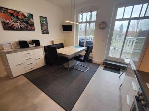 een kantoor met een bureau en een tafel en stoelen bij Villa Parkblick, Whg. 17 in Kühlungsborn