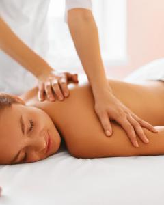 a woman getting a massage from a therapist at Rhön & Relax Schwarze Berge - Garten in Wildflecken