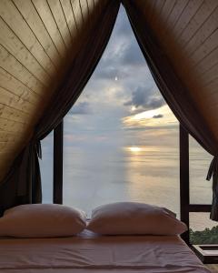 a bed in a room with a view of the ocean at Panorama Sarpi 029 in Batumi