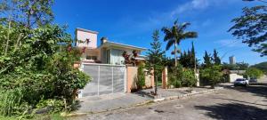 una casa con una puerta de garaje blanca en una calle en Demi-suíte privativa em casa familiar 2, en Itajaí