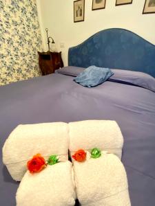 a bed with white towels and red flowers on it at La casa di Beatrice e Francesca in Turin