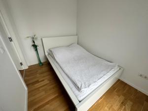 um pequeno quarto branco com uma cama em Modernes Apartment I Parkplatz I Terrasse em Blumberg