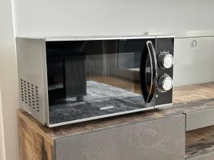 a microwave oven sitting on top of a counter at Modernes Apartment I Parkplatz I Terrasse in Blumberg