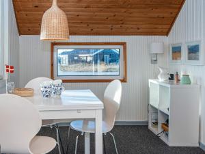 a dining room with a white table and white chairs at 5 person holiday home in Lemvig in Lemvig