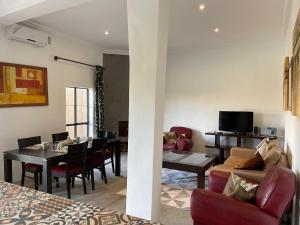 ein Wohnzimmer mit einem Tisch und einem Esszimmer in der Unterkunft Villa exclusive piscine privée proche centre in Marrakesch