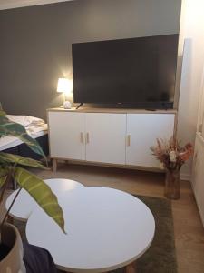 a living room with a flat screen tv on a white cabinet at Elegant Apartment In Central Aalborg in Aalborg