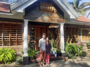 a man and woman standing in front of a house at Sopanam Heritage Thekkady in Thekkady