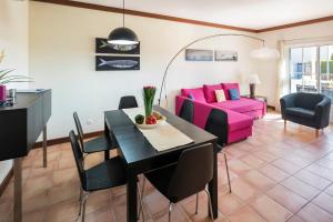 a living room with a table and a pink couch at TERRAÇOS DE BENAGIL 20 in Benagil