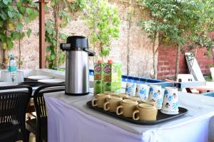 een tafel met een koffiepot en kopjes erop bij Wada Chirebandi in Gimvi