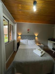 a bedroom with a bed with a wooden ceiling at Tally Hall - Casa Pequena in Morro dos Bugres