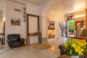 a living room with a chair and a mirror at SólleRooms in Sóller