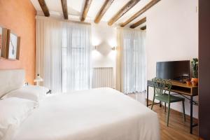 a bedroom with a bed and a desk with a computer at Hostal Pichorradicas in Tudela