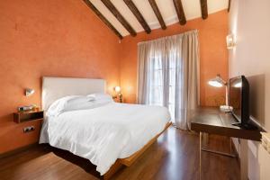 Un dormitorio con una gran cama blanca y una ventana en Hostal Pichorradicas en Tudela