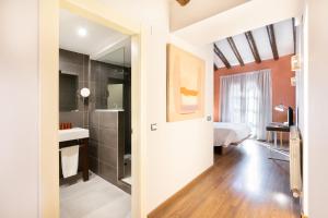 Habitación con baño con ducha y lavabo. en Hostal Pichorradicas en Tudela