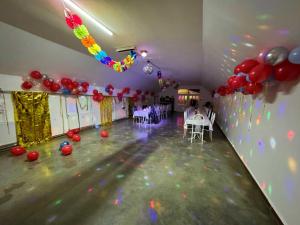 a party hall with balloons and tables and chairs at Koma Vendégház in Aporliget