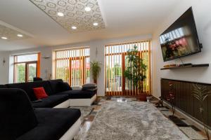 a living room with a couch and a flat screen tv at Koma Vendégház in Aporliget